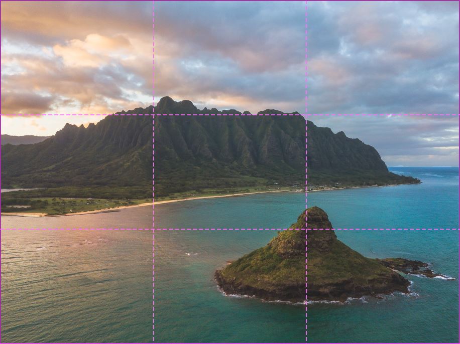 image of an island in the ocean with a mountain range in the back at sunset with the rule of third grid overlayed