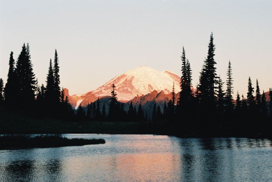 image of mount rainier national park with a red glow and reflection on lake